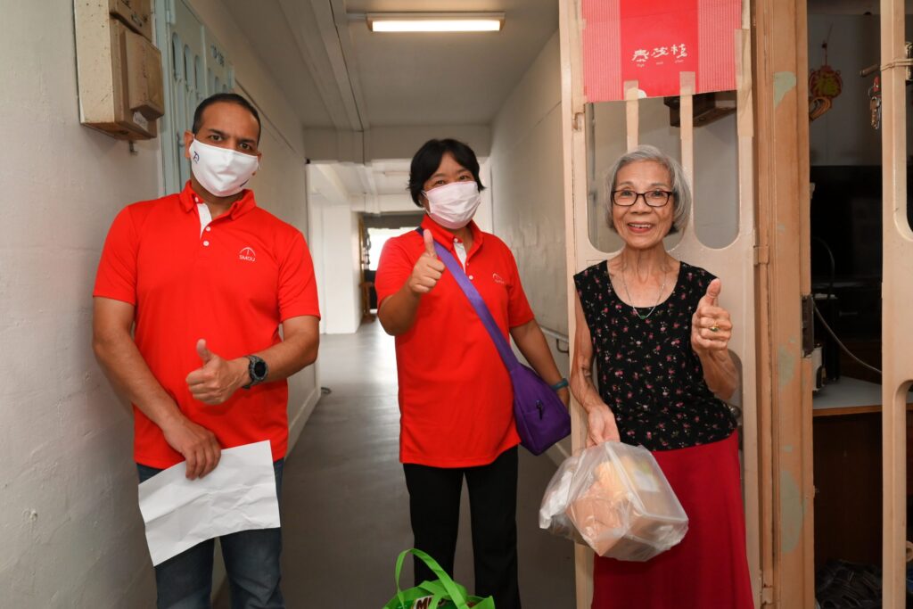 Brother Akhil Agarwal & Sister Yang Mei giving out a care bag to a resident